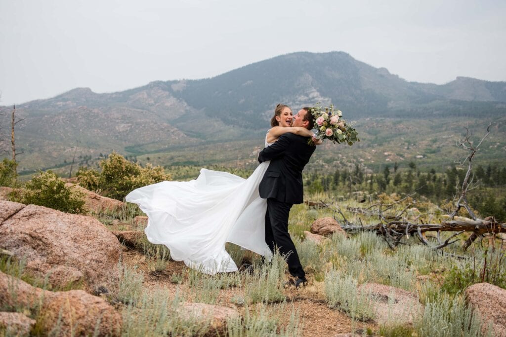 groom swinging bride around dress flying colorado elopement
