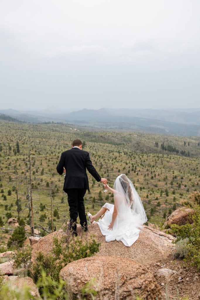 newlywed couple drinking champagne top of mountain
